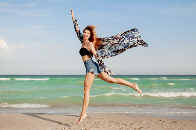 Full-length portrait  of pretty slim girl enjoying horizon view at ocean resort.