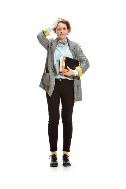 Full length portrait of a sad female student holding books isolated on white space