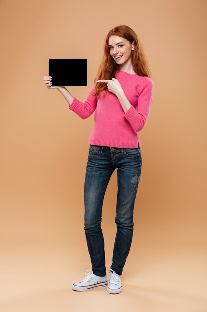 디지털 태블릿에 만족 예쁜 빨간 머리 소녀 가리키는 손가락의 전체 길이 초상화