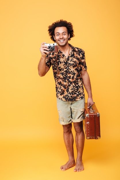 Full length portrait of a smiling african man tourist