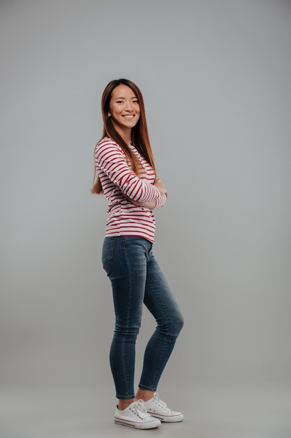 Full length portrait of a smiling asian girl standing