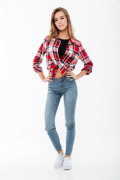 Full length portrait of a smiling casual girl in plaid shirt