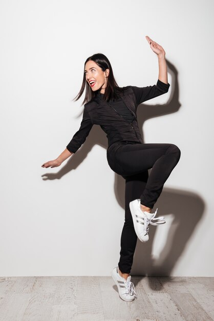 Full length portrait of a smiling casual woman posing