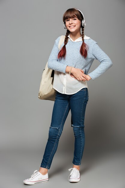 Full length portrait of a smiling pretty schoolgirl