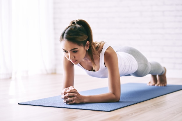 Full length portrait of sportswoman standing in plank position