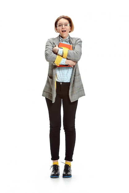 Free photo full length portrait of a surprised female student holding books isolated on white space