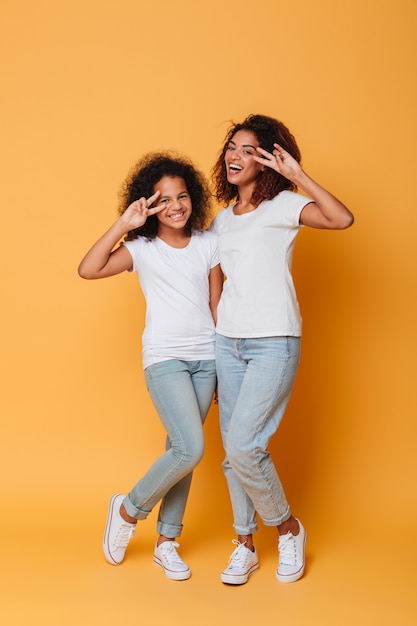 Full length portrait of two happy african sisters standing