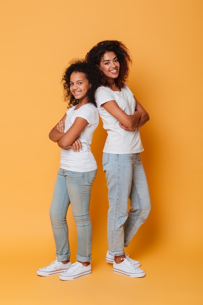 Full length portrait of two happy african sisters