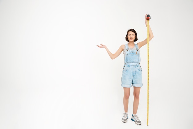 Full length portrait of woman measure herself with tape