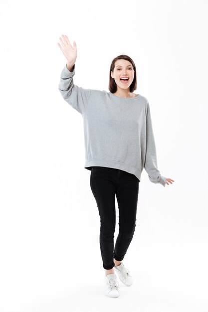 Full length portrait of a woman waving hand