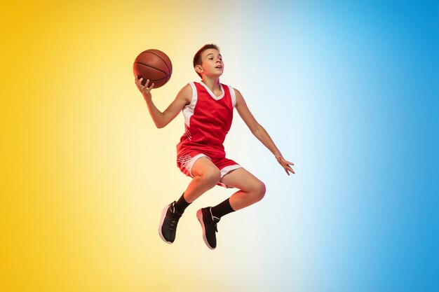 Полный портрет молодого баскетболиста с мячом на градиентном фоне