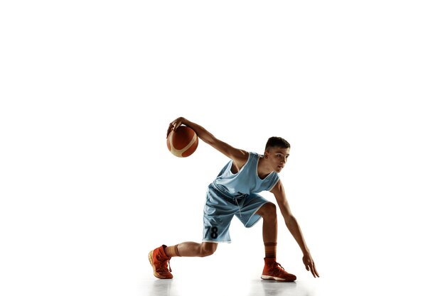 Full length portrait of young basketball player with a ball isolated on white studio background. Teenager training and practicing in action, motion. Concept of sport, movement, healthy lifestyle, ad.