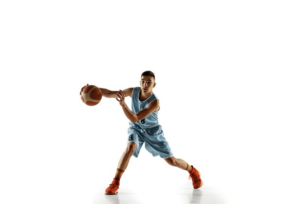 Full length portrait of young basketball player with a ball isolated on white studio background. Teenager training and practicing in action, motion. Concept of sport, movement, healthy lifestyle, ad.