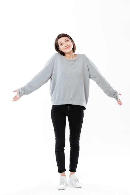 Full length portrait of a young cinfused woman shrugging shoulders