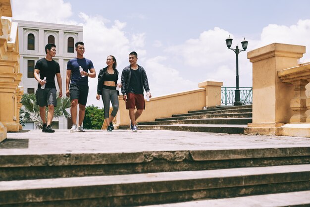 Full length portrait of young people taking break from a jogging exercise walking outdoors