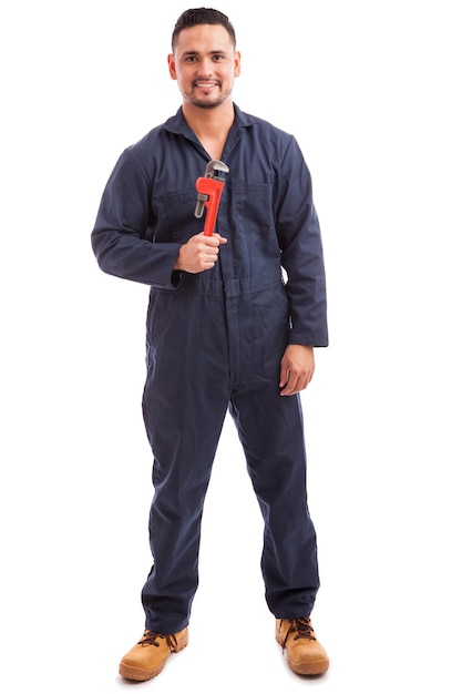 Free photo full length portrait of a young plumber holding a wrench and ready for work on a white background