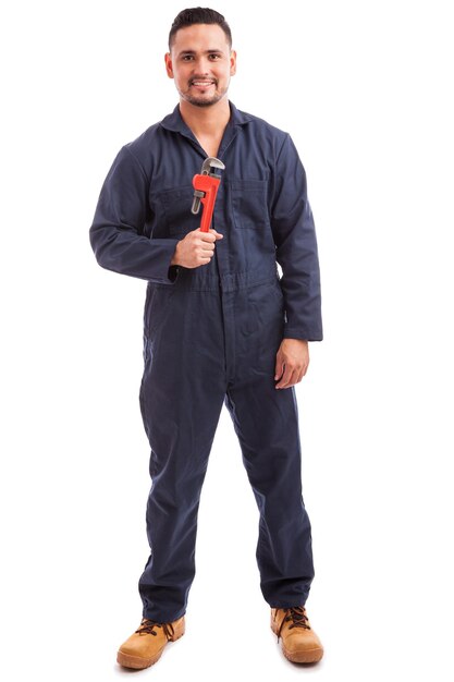 Full length portrait of a young plumber holding a wrench and ready for work on a white background