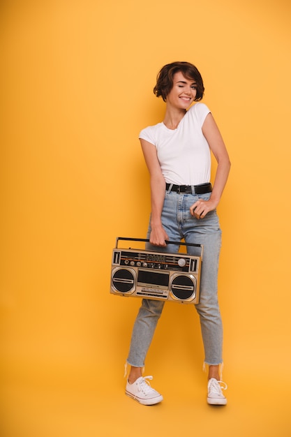 Free photo full length portrait of a young woman holding record player