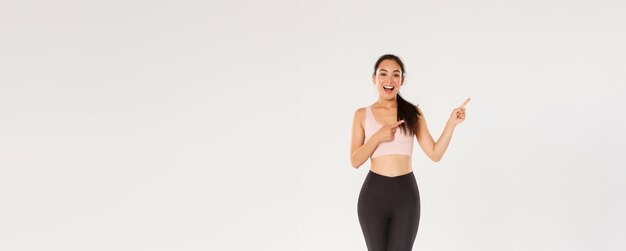 生意気な魅力的な女性アスリート アジア フィットネス女の子スポーツウェア ポインティング指 upp の完全な長さ