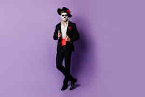 Free photo full-length shot of charming guy with red satin belt under black jacket, posing in halloween costume.