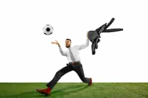 Бесплатное фото Полнометражный снимок молодого бизнесмена, играющего в футбол, изолированные на белом.