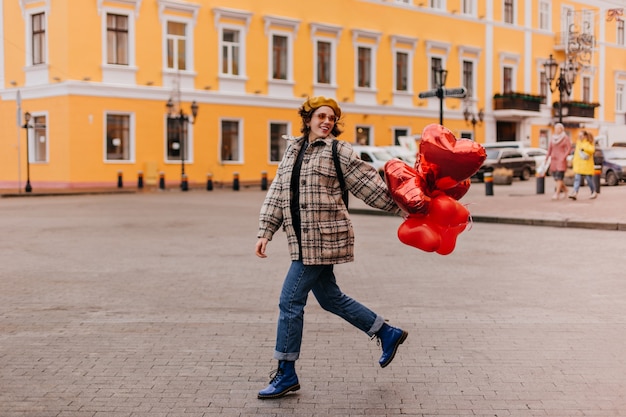 Free photo full-length shot of walking stylish woman in blue shoes dr. martins and tweed oversize jacket