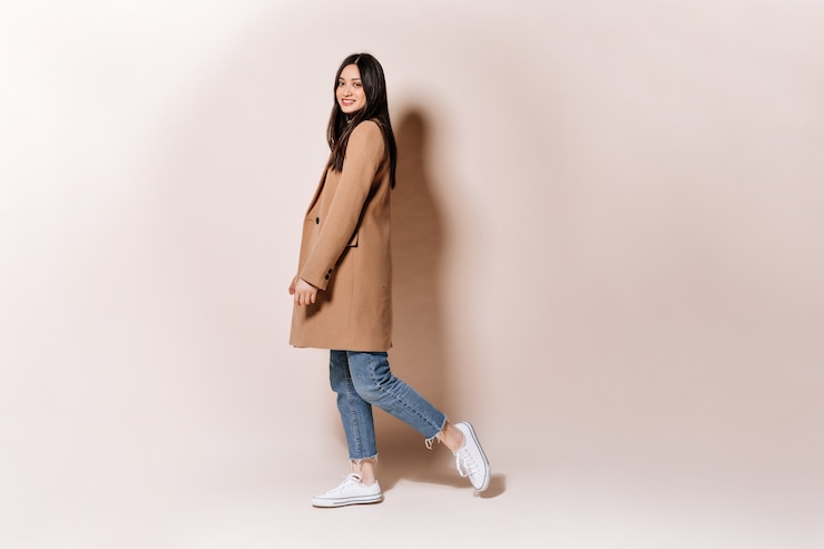 無料Photo スタイリッシュなコートとジーンズの女性のフルレングスのショット