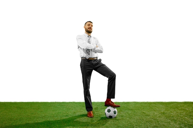 Полнометражный снимок молодого бизнесмена, играющего в футбол, изолированного на белой стене