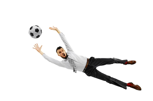 Полнометражный снимок молодого бизнесмена, играющего в футбол, изолированного на белой стене