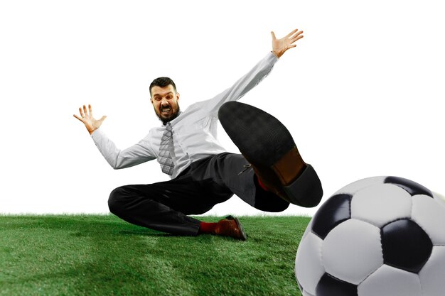 Full length shot of a young businessman playing football isolated on white wall