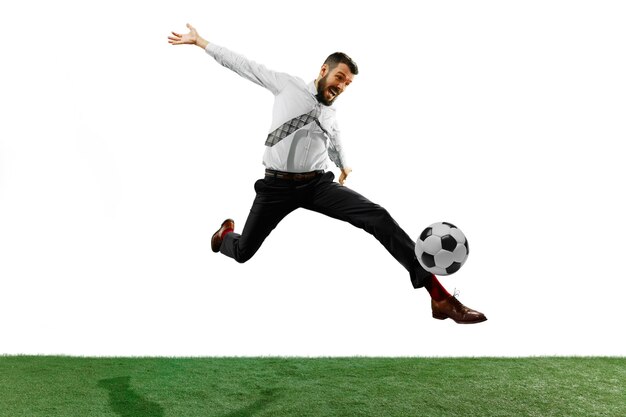 Full length shot of a young businessman playing football isolated on white wall