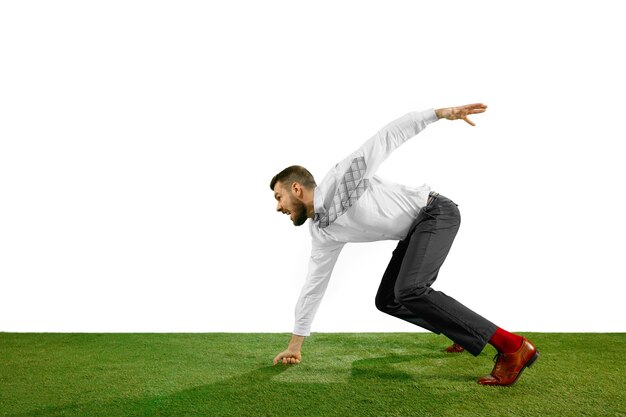 Full length shot of a young businessman playing football isolated on white.