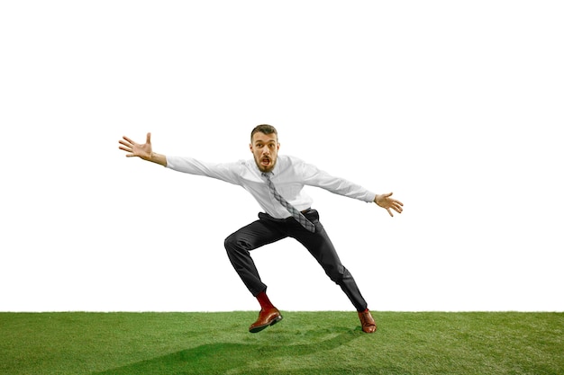 Full length shot of a young businessman playing football isolated on white.