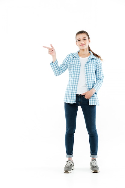 Full-length shot of young smiling young woman showing at copy space