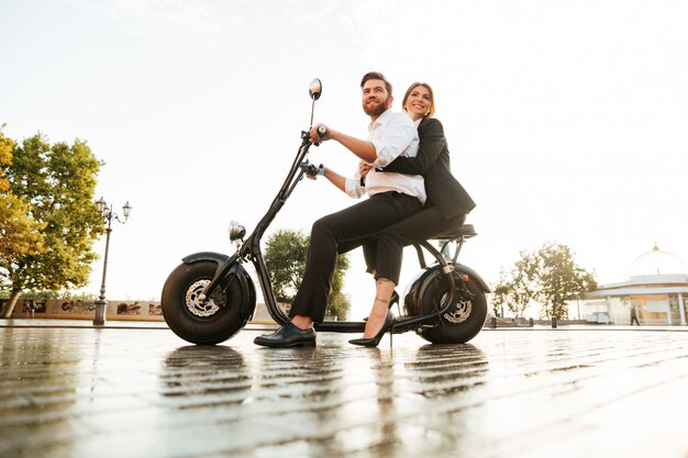 Full length side view image of joyful business couple