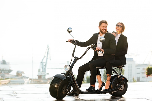 Full length side view image of laughing business couple