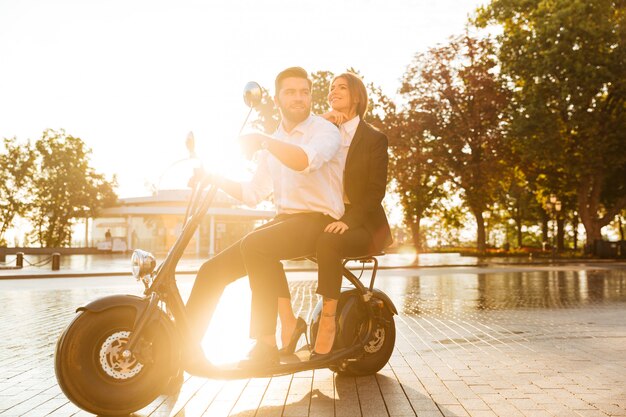 Full length side view image of smiling business couple