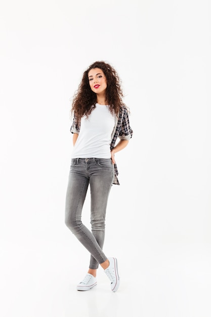 Full length Smiling curly woman posing   over white wall