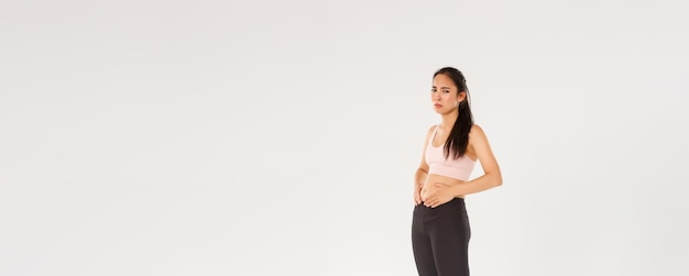 L'intera lunghezza della ragazza asiatica di forma fisica sconvolta e cupa che cerca di perdere peso toccando la pancia non riesce a vedere la risoluzione