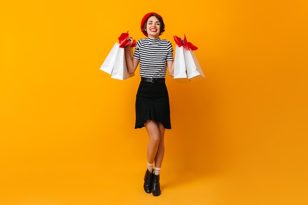 Full length view of beautiful brunette woman with store bags