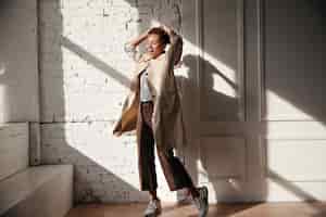 Free photo full length view of ecstatic woman in trench coat
