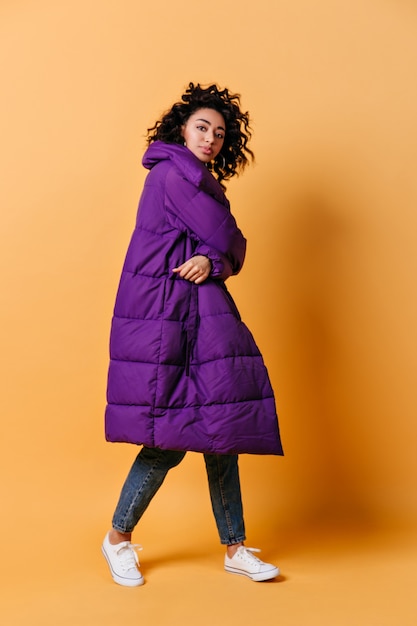 Free photo full length view of young woman in long down jacket