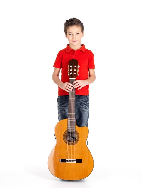 Полный портрет кавказского мальчика с акустической гитарой - изолированные