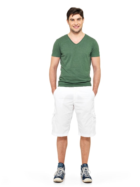 Ritratto completo dell'uomo bello felice sorridente in pantaloncini bianchi e maglietta verde isolati su bianco