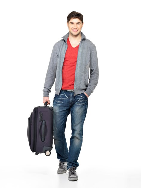 Full portrait of smiling happy man with grey suitcase - isolated on white
