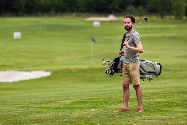 ゴルフコースでフルショットの成人男性