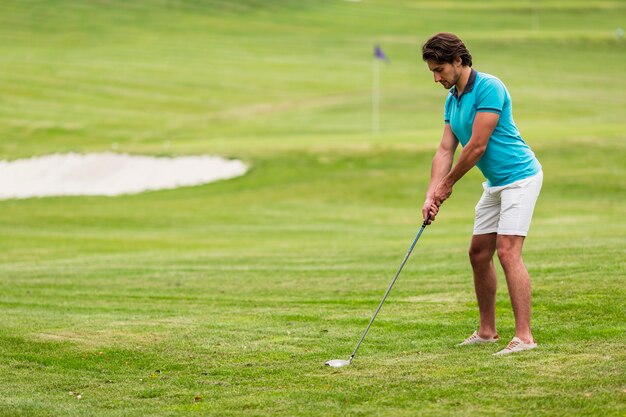Полный взрослый мужчина, играющий в гольф