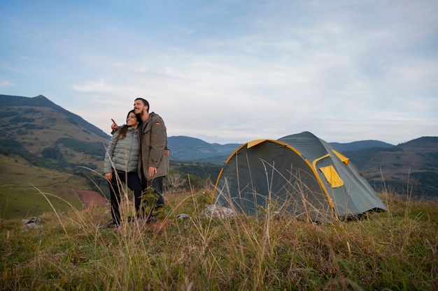 Free photo full shot adventurous couple bivouacking