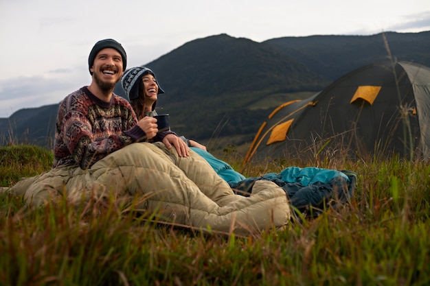 Full shot adventurous couple bivouacking