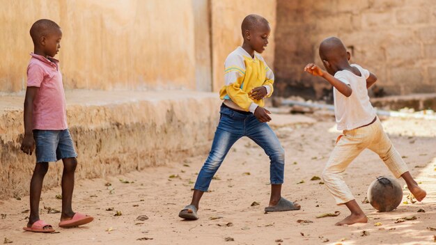 Full shot african kids playing with ball